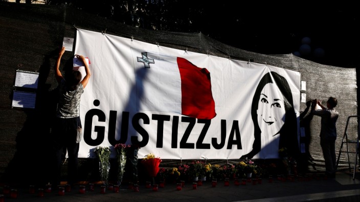 Activists, for the second time in a day, hang a banner demanding justice for assassinated anti-corruption journalist Daphne Caruana Galizia on hoarding surrounding the Great Siege monument, in Valletta