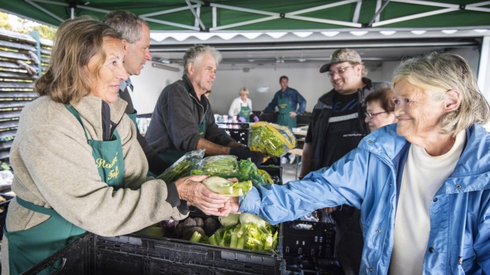 Starnberg: Jeden Donnerstag helfen 25 Menschen ehrenamtlich, damit die Lebensmittelausgabe reibungslos klappt. Darunter Marcella Pechaty (vorne links), die einer Starnbergerin das gewünschte Gemüse gibt.