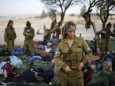 Israeli soldier of Caracal battalion stands next to backpacks after finishing march in Israel's Negev desert