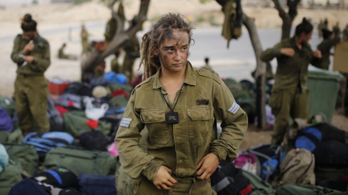 Israeli soldier of Caracal battalion stands next to backpacks after finishing march in Israel's Negev desert