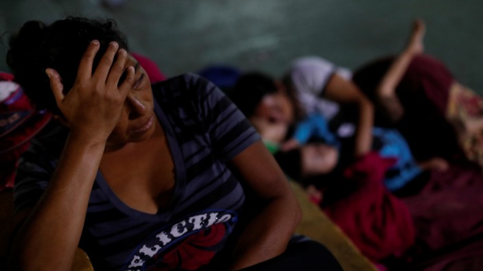 Maria Nino, migrant from Honduras and part of a caravan trying to reach the U.S., rests next to her relatives in a public square as they wait to regroup with more migrants, in Tecun Uman