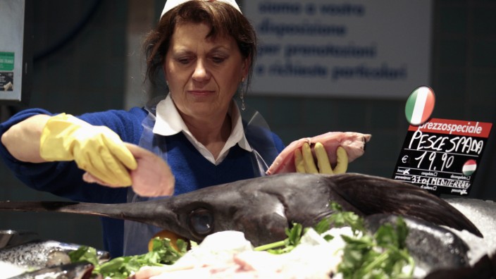 An employee prepares freshly sliced swordfish at the Panomara supermarket in Parma
