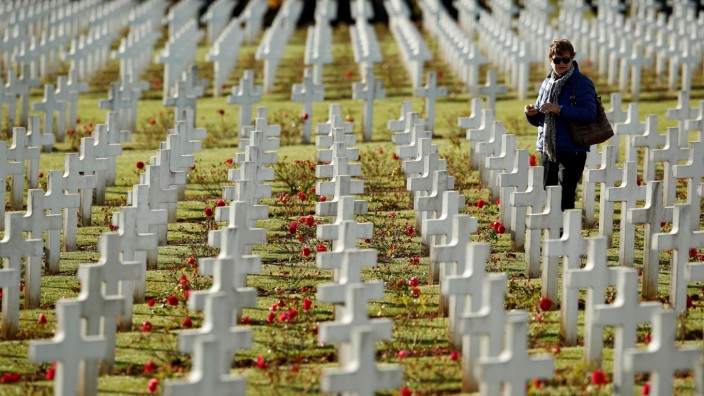 A woman walks among the tombstones at the cemetery outside the WWI Douaumont Ossuary near Verdun