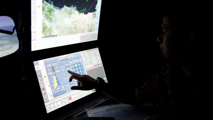 A senior pilot of Lion Air Group points at the control computer during a routine practice session on Boeing 737-900ER simulator at Angkasa Training Center near Jakarta