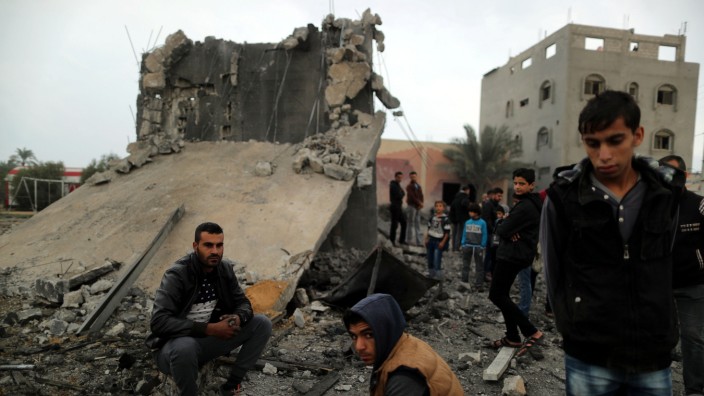 Gazastreifen - Palästinenser vor einem zerstörten Haus