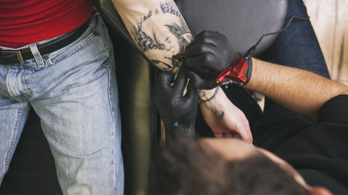 Tattoo artist at work model released Symbolfoto property released PUBLICATIONxINxGERxSUIxAUTxHUNxONL