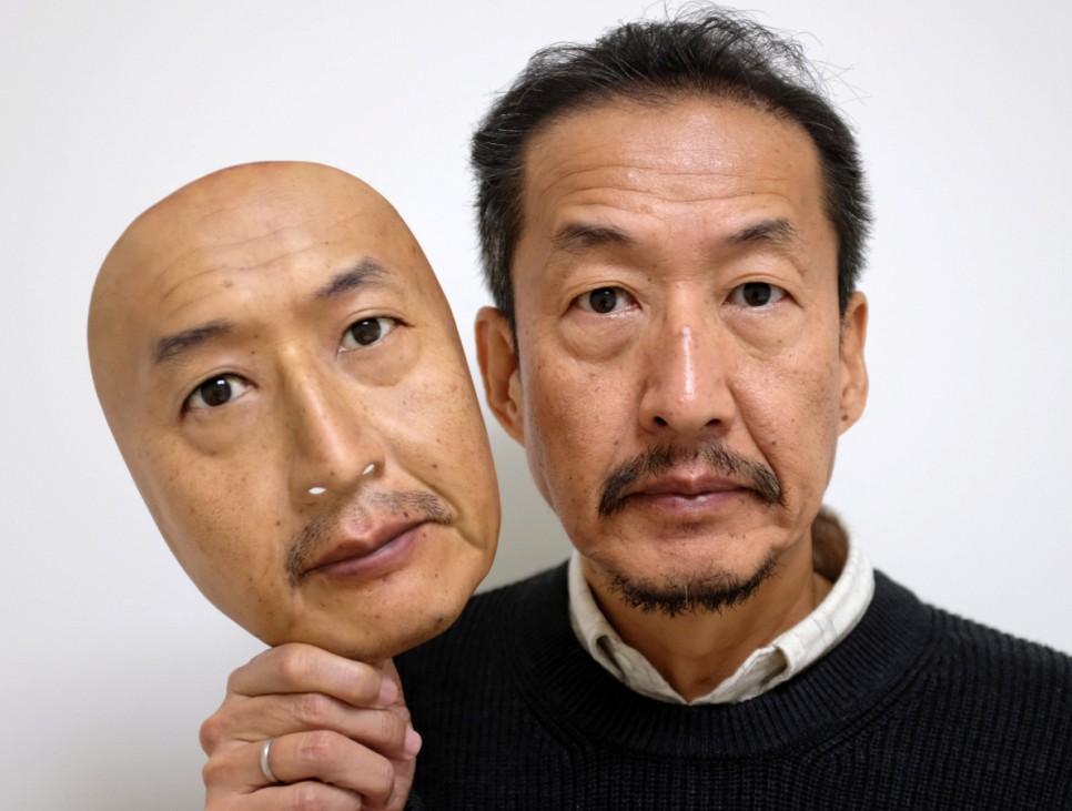 REAL-f Co. President Osamu Kitagawa shows off a super-realistic face mask at his factory in Otsu