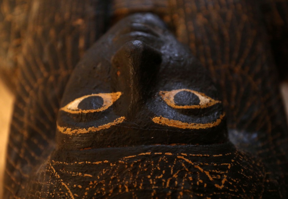 A carved black wooden sarcophagus inlaid with gilded sheets is seen inside a tomb at al-Assassif Necropolis, in Luxor