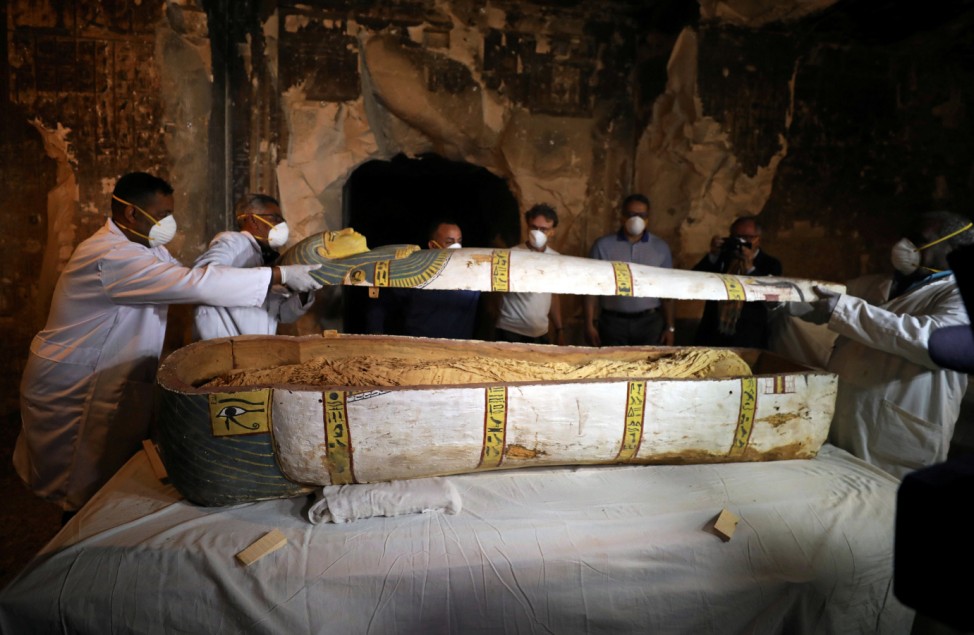 Archaeologists remove the cover of an intact sarcophagus inside the tomb TT33 in Luxor