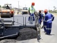 Labourers carry out surfacing work on a road near the Zambian capital Lusaka