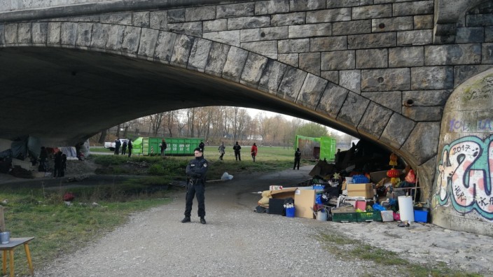 Behörden-Beschluss: Die Habseligkeiten der Wohnungslosen unter der Wittelsbacherbrücke werden unter Polizeischutz in grünen Containern entsorgt.