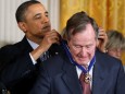 FILE PHOTO: U.S. President Barack Obama awards the Medal of Freedom to former U.S. President George H.W. Bush during a ceremony at the White House in Washington