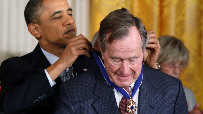 FILE PHOTO: U.S. President Barack Obama awards the Medal of Freedom to former U.S. President George H.W. Bush during a ceremony at the White House in Washington