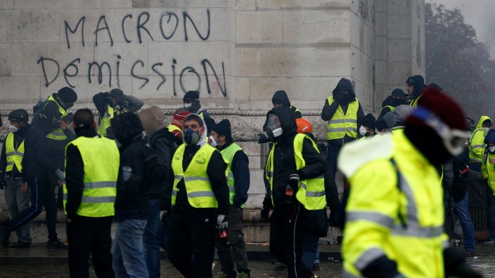 The message 'Macron Resign' is seen on the Arc de Triomphe as protesters wearing yellow vests, a symbol of a drivers' protest against higher diesel taxes, demonstrate at the Place de l'Etoile in Paris