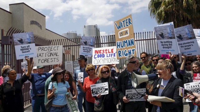 Demonstrators march outside a Nestle water bottling plant in Los Angeles, California