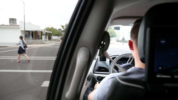 Waymo Trained Driver Derek Sirakis looks out the windshield as the car stops for pedestrians during a demonstration in Chandler, Arizona
