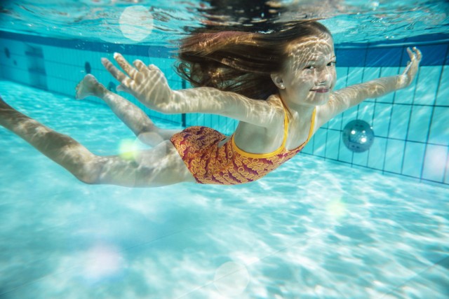 Portrait of smiling girl swimming under water in swimming pool model released Symbolfoto property re