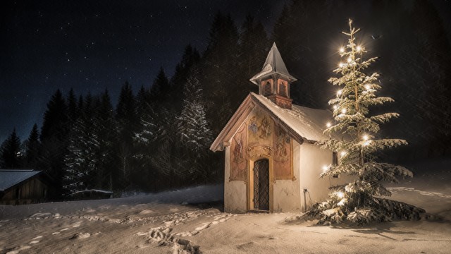 Weihnachten in Bayern: Neben all dem Bösen, das die Zeit zwischen den Jahren prägt, steht auch das Helle und Tröstliche, das im weihnachtlichen Lichterglanz zum Ausdruck kommt - wie hier am Christbaum und an der Kapelle im oberbayerischen Elmau.