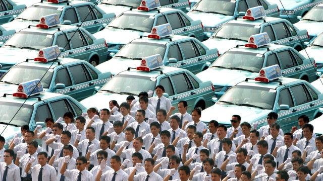 Chinese taxi drivers attend ceremony putting Volkswagon Santana 3000 cars into use at taxi company in ...