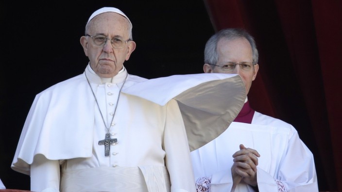 Papst Franziskus: Papst Franziskus mit flatternder Robe und flankiert von Zeremonienmeister Guido Marini blickt von der Loggia des Petersdoms herunter.