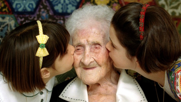FILE PHOTO: The World's oldest woman, Jeanne Calment, 120 years old, is kissed by two young girls during a special ceremony in a retirement home in Arles