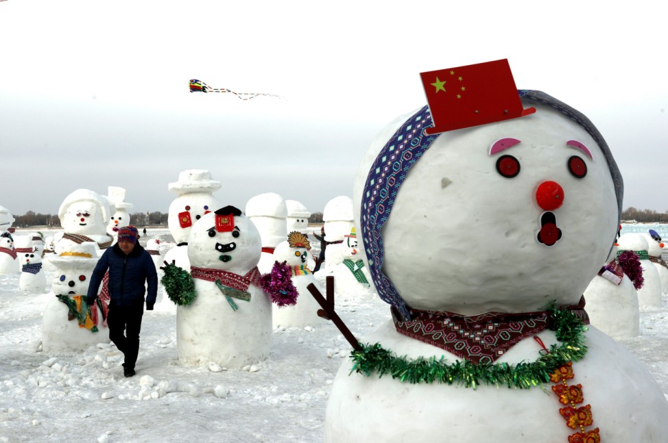 A man walks between snowmen on Songhua River that displays 2019 snowmen as a part of annual ice festival, in the northern city of Harbin, Heilongjiang province
