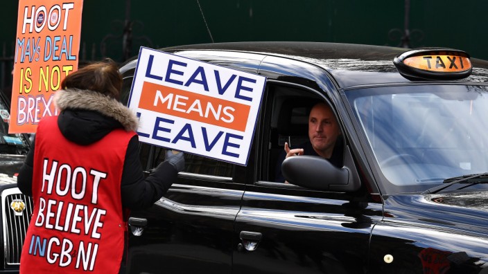 A pro-Brexit protester speaks to a taxi driver outside the Houses of Parliament in London