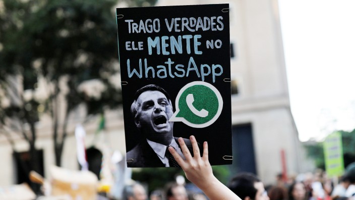 A woman holds a sign with an image of presidential candidate Jair Bolsonaro during a protest in Sao Paulo