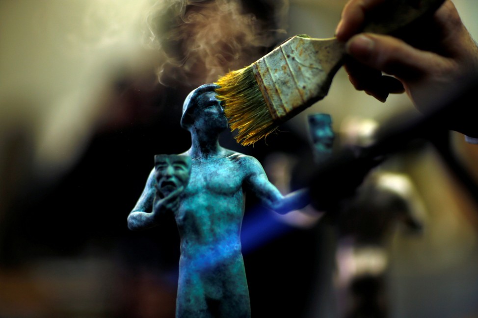 A worker applies a patina on 'The Actor' statuette during a media event on the production of the statuettes for the 25th annual Screen Actors Guild Awards at American Fine Arts Foundry in Burbank