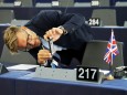 A man takes a picture of a Union Jack flag placed on the desk of a MEP ahead of a debate on BREXIT at the European Parliament in Strasbourg