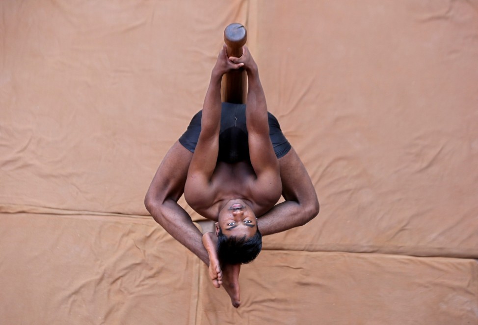 A participant practices 'Mallakhamb' during a practice session for the upcoming competition to promote the sport, in Ahmedabad