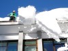 A worker removes snow from the roof of a building in Davos