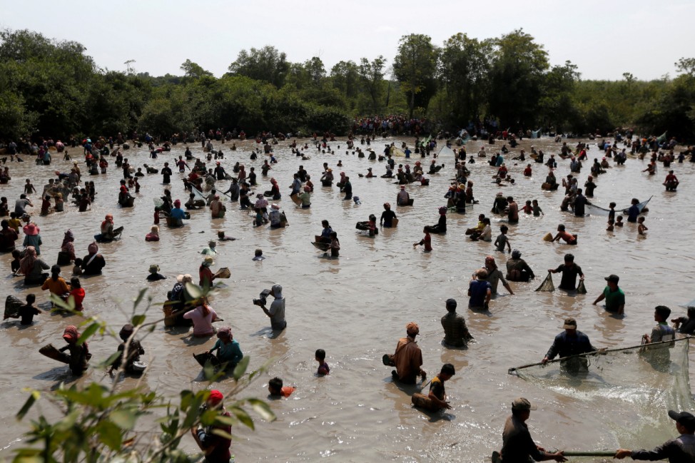 People collect fish at the Krom lake in Tbong Khmum province