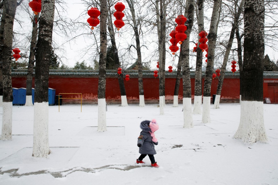 A girl draws a track into the snow in Ditan Park in Beijing