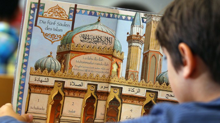 Islamunterricht Ein Junge liest in einem Schulbuch über die fünf Säulen des Islam