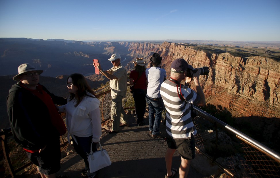People take photos as the sun sets at the Grand Canyon National Park in northern Arizona