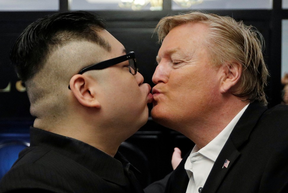 Howard X, an Australian impersonating North Korean leader Kim Jong Un, kisses an impersonator of U.S. President Donald Trump at the La Paix Hotel in Hanoi