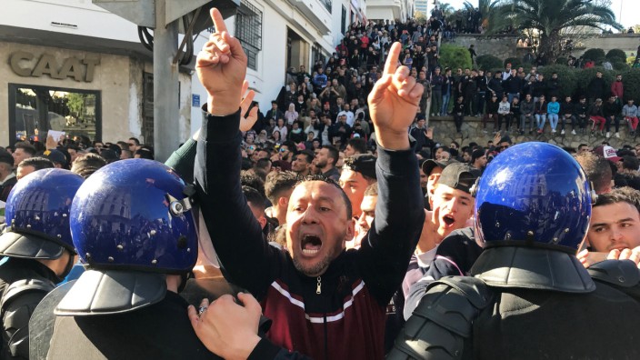 A man gestures and shouts near riot police during a protest against President Abdelaziz Bouteflika's plan to extend his 20-year rule by seeking a fifth term in April elections in Algiers