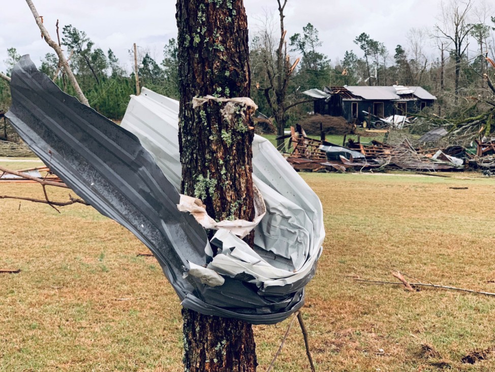 A piece of metal is seen wrapped around a tree following a tornado in Beauregard, Alabama