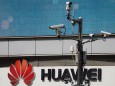Surveillance cameras are seen next to a Huawei company logo outside a shopping mall in Shanghai