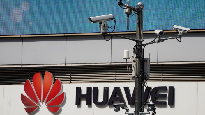 Surveillance cameras are seen next to a Huawei company logo outside a shopping mall in Shanghai