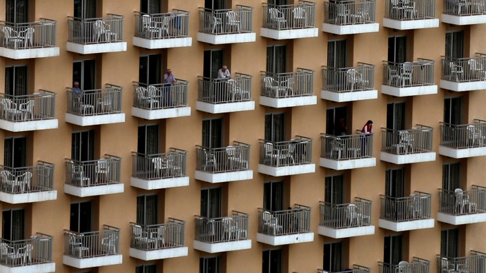Touristen stehen auf den Balkonen eines Hotels im spanischen Benidorm.