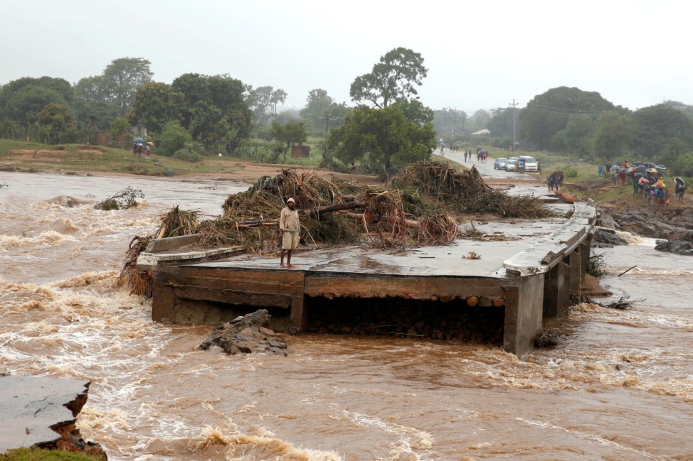 A man looks at a washed away bridge along Umvumvu river following Cyclone Idai in Chimanimani