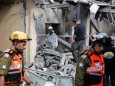 Israeli policemen and soldiers inspect a damaged house that was hit by a rocket north of Tel Aviv Israel