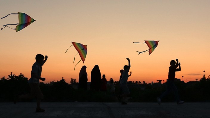 Naher Osten: Abends in Bagdad: Kinder spielen in einem Park mit Drachen.