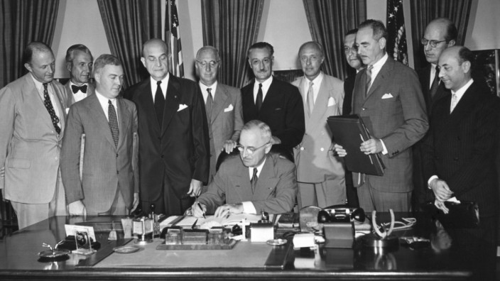 President Harry Truman signs the North Atlantic Pact on Aug. 24, 1949. Around him diplomats of signatory nations and American officials to witness this signing. Nations represented are United Kingdom, Denmark, Canada, Norway, France, Belgium, Portugal, Ne