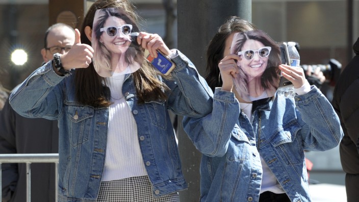 Bildungssystem: Zwei junge Frauen halten sich selbstgemachte Lori-Loughlin-Masken vor ihr Gesicht. Loughlin ist aufgrund des Skandals um die Hochschul-Bestechungen in den USA angeklagt.