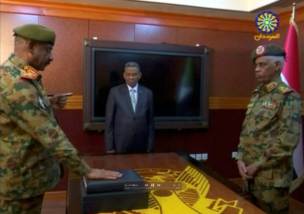Sudan's Defence Minister Awad Mohamed Ahmed Ibn Auf, head of Military Transitional Council looks on as military's chief of staff, Lieutenant General Kamal Abdul Murof Al-mahi is sworn in as a deputy head of Military Transitional Council in Sudan