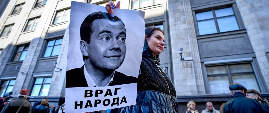 Eine Frau demonstriert in Moskau gegen Dmitrij Medwedjew