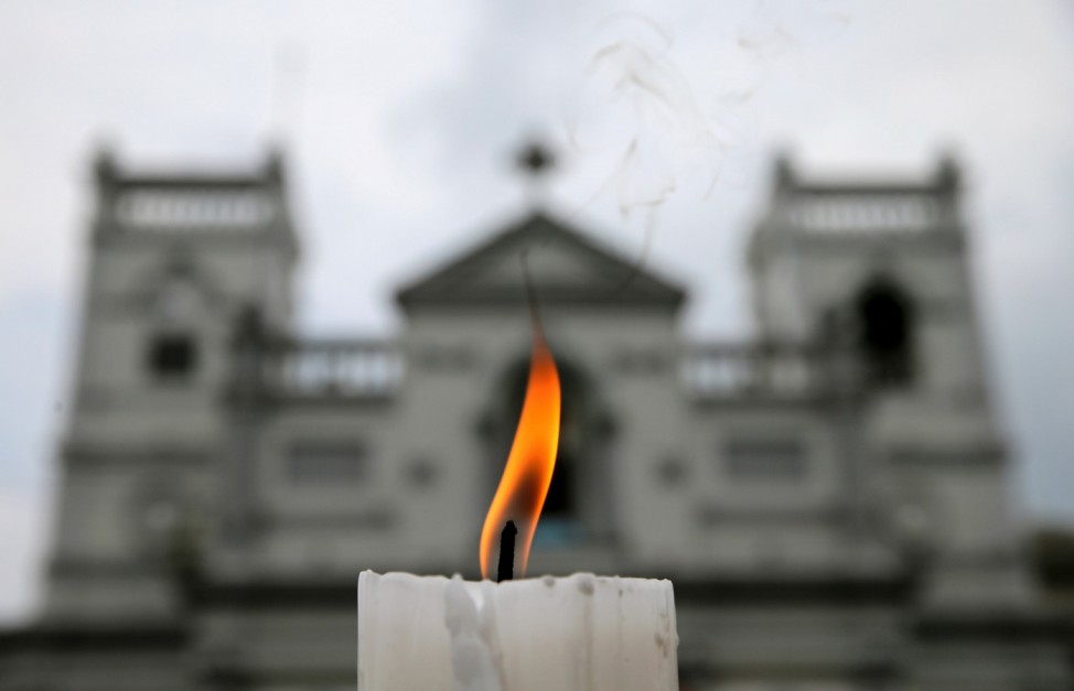 A candle burns outside St. Anthony's Shrine a week after a string of suicide bomb attacks across the island on Easter Sunday, in Colombo